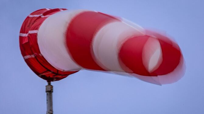 Windsack weht bei Regen und kräftigem Wind am Mast Windsack weht bei Regen und kräftigem Wind am Mast