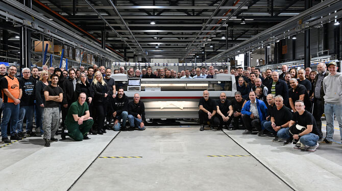 Maschinenbau Beschäftigte von Stoll in Reutlingen haben sich um die symbolisch letzte von ihnen hergestellte Flachstrickmaschine versammelt.
