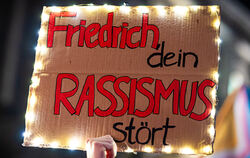 Der Schriftzug »Friedrich, dein Rassismus stört« ist bei einer Kundgebung auf dem Opernplatz auf dem Plakat eines Demonstranten