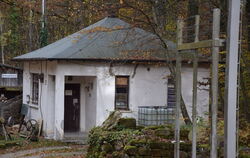 Ein Wachhäuschen samt Stacheldrahtzaun auf dem Gelände des Natursteinparks.  Die Anlagen erinnern an die frühere Nutzung des Gel