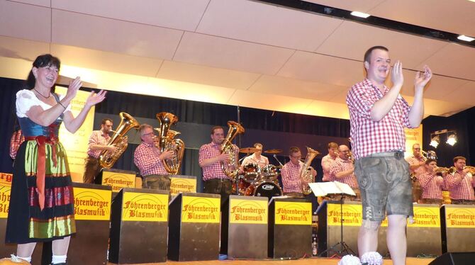 Dirigent Toni Hinderer wandte sich auch dem Publikum zu und förderte damit die gute Stimmung in der Gutenberghalle.  FOTO: SANDE