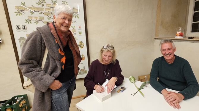 Die Kirchentellinsfurter Autorin Birgit Juresa (Mitte) signiert im Beisein ihres Ehemannes Ivi ihr Buch »Bürotope« für eine Besu