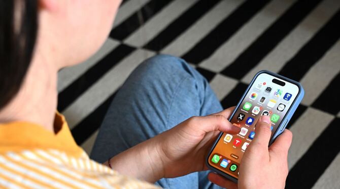 Eine Jugendliche sitzt am Smartphone (Archivbild) Eine Jugendliche sitzt am Smartphone (Archivbild)