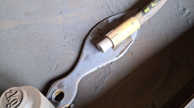 Einer der Uhrenzeiger in der Restauration. Er befindet sich gerade in der Abstrahlkammer. Mit feinem Edelstahlstaub wird er abge