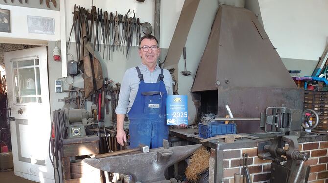 Josef Leippert mit der Plakette des Innenministers vor Amboss und Esse.
