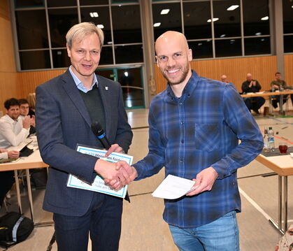 Bürgermeister Peter Nußbaum (links) nimmt zu Beginn der Gemeinderatssitzung die Petition für den Erhalt der Holzelfinger Schule