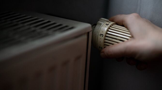 Eine Person dreht am Thermostat einer Heizung. Künftig soll die Wärme in Pliezhausen klimaschonend entstehen.