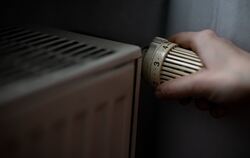 Eine Person dreht am Thermostat einer Heizung. Künftig soll die Wärme in Pliezhausen klimaschonend entstehen.