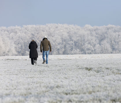 Spaziergänger sind bei Minusgraden im Schnee bei Pfronstetten unterwegs.