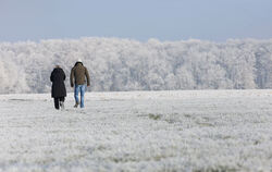Spaziergänger sind bei Minusgraden im Schnee bei Pfronstetten unterwegs.