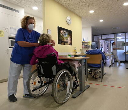 Im Foyer wird das Mittagessen serviert. Drei Patienten sitzen in ihren Rollstühlen am Tisch. Für sie wäre es die schönste Besche