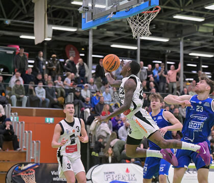 Niko Kaps (links) beobachtet den Teamkollegen John Saigge (mit Ball) im Spiel gegen die Gießen Pointers bei einer eleganten Flug