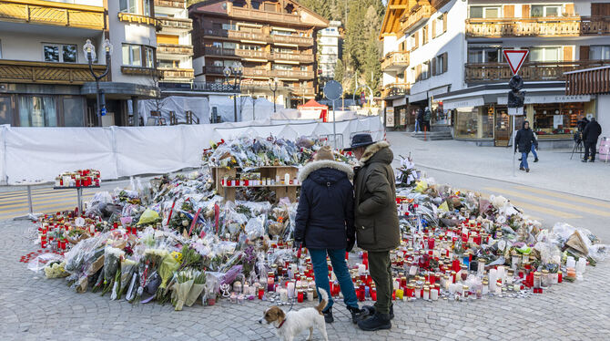 Trauer in Crans-Montana: Menschen legen Blumen und Kerzen nieder zum Gedenken an die Opfer des Brandes.