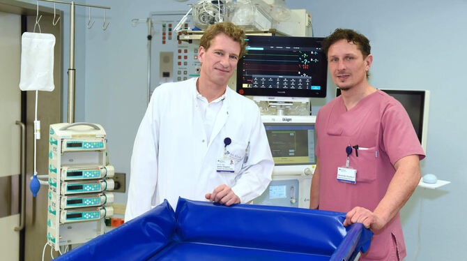 Hinter einem speziellen Verbrennungsbad stehen Professor Dr.  Adrien Daigeler (links), Direktor der Klinik für Verbrennungschiru