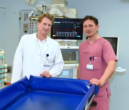 Hinter einem speziellen Verbrennungsbad stehen Professor Dr.  Adrien Daigeler (links), Direktor der Klinik für Verbrennungschiru