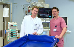 Hinter einem speziellen Verbrennungsbad stehen Professor Dr.  Adrien Daigeler (links), Direktor der Klinik für Verbrennungschiru