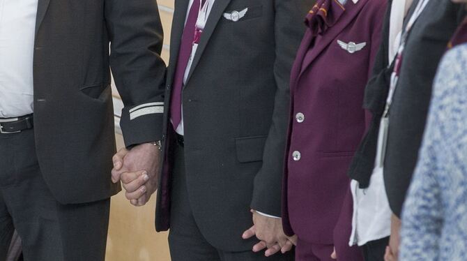 Mitarbeiter von Germanwings halten sich an den Händen und gedenken in einer Schweigeminute den Opfern des abgestürzten Germanwin