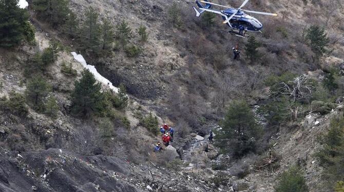 Ein Hubschtrauber kreist über Wrackteilen des verunglückten Airbus A320 in den französischen Alpeb. Fote: Guillaume Horcajuel