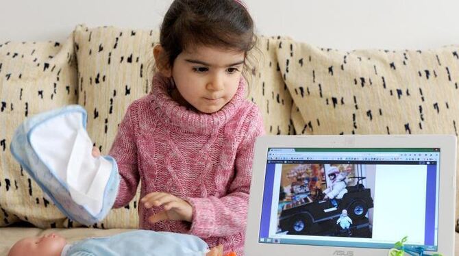 Was man mit zwei Jahren so braucht: Mariam spielt mit ihrer Puppe, Überraschungseiern und ihrem Laptop. Foto: Ingo Wagner