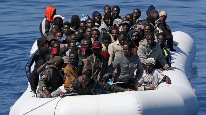 Im Mittelmeer wird ein Boot mit afrikanischen Flüchtlingen von der italienischen Küstenwache abgeschleppt. Foto: Alessandro d Im Mittelmeer wird ein Boot mit afrikanischen Flüchtlingen von der italienischen Küstenwache abgeschleppt. Foto: Alessandro d