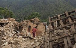 Ein Junge sucht sich am Rande von Kathmandu durch Trümmer von beim April-Beben zerstörten Häuser seinen Weg. Foto: Hemanta Sh