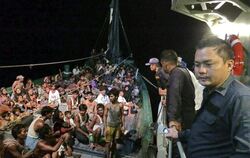 Ein Boot mit aus Myanmar geflüchteten Rohingya neben einem Schiff der thailändischen Marine. Foto: Royal Thai Navy