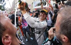 Monaco-Sieger Nico Rosberg seinen Team-Mitgliedern einen Schluck aus der Champagner-Flasche. Foto: Valdrin Xhemaj