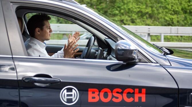 Fährt auch ganz ohne Hände am Lenkrad: Ein Bosch Mitarbeiter demonstriert, wie weit das selbstfahrende Auto schon ist.