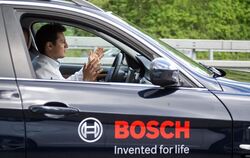 Fährt auch ganz ohne Hände am Lenkrad: Ein Bosch Mitarbeiter demonstriert, wie weit das selbstfahrende Auto schon ist.