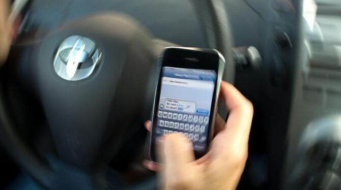 Ungute Ablenkung: Eine Frau schreibt eine SMS am Steuer. Foto: Arno Burgi