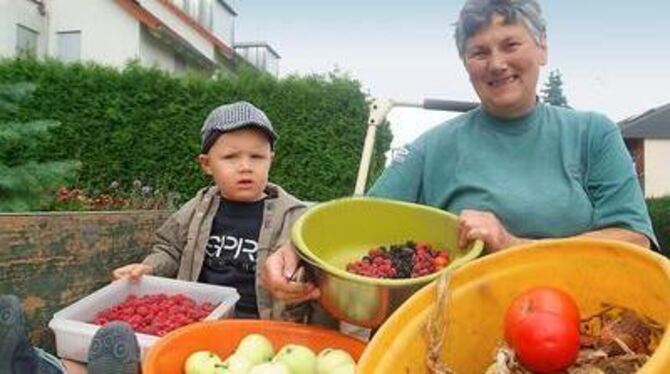 Mit Äpfeln, Zwiebeln, Tomaten und Beeren: Marianne Kern und der zweieinhalbjährige Fabian Greiner in Neuhausen nach der Ernte au