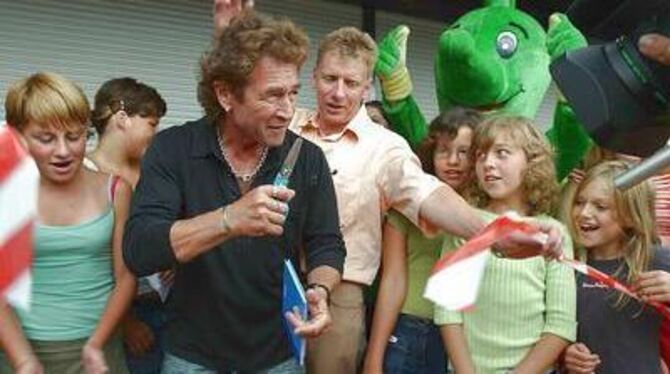 Umlagert von Fans durfte Peter Maffay am Samstag in Münsingen das Band zum Tabaluga-Haus durchschneiden. FOTO: BAIER
