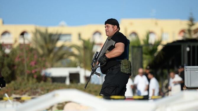Ein bewaffneter Polizist steht am Strand vor dem Imperial Marhaba Hotels in Sousse. Mindestens 39 Menschen starben bei dem Terro