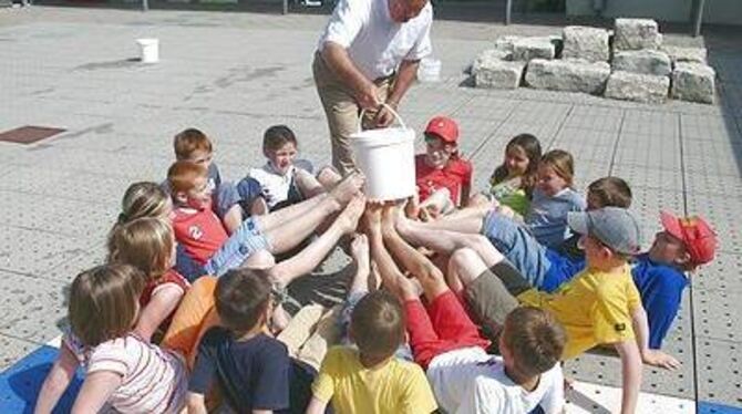 Experiment mit Gaudi-Faktor. Alle Füße in die Mitte und auf Wilfried Maschkes Kommando den Wassereimer herum gereicht. GEA-FOTO