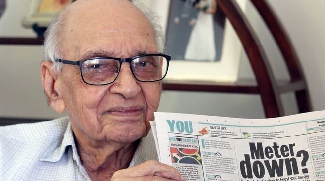 Mahinder C. Watsa hält in seinem Wohnzimmer in Mumbai, Indien, seine tägliche Sex-Kolumne in einer Ausgabe des Mumbai Mirror in Mahinder C. Watsa hält in seinem Wohnzimmer in Mumbai, Indien, seine tägliche Sex-Kolumne in einer Ausgabe des Mumbai Mirror in