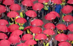 Demonstranten mit roten Regenschirmen in Hamburg während einer Aktion der Gewerkschaft Verdi unter dem Motto «Tarifverträge s