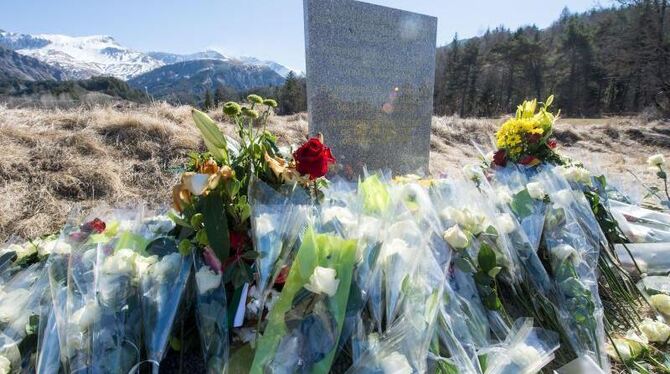 Inmitten von Blumen steht eine steinerne Gedenkstele mit der Aufschrift "In Erinnerung an die Opfer des Flugzeugunglücks vom