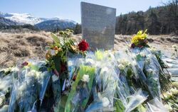 Inmitten von Blumen steht eine steinerne Gedenkstele mit der Aufschrift "In Erinnerung an die Opfer des Flugzeugunglücks vom 