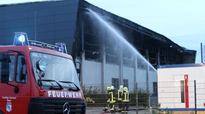 Feuerwehrleute löschen in Nauen einen Brand in der Turnhalle des Oberstufenzentrums Havelland, die als Notunterkunft für etwa