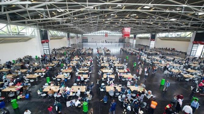 Erster Zufluchtsort nach der Flucht: Migranten in einer Messehalle in München. Foto: Angelika Warmuth
