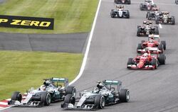 Lewis Hamilton (l) zieht direkt nach dem Start innen an Nico Rosberg vorbei. Foto: Diego Azubel