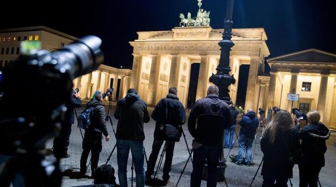 Frühaufsteher fotografieren am Brandenburger Tor in Berlin die Mondfinsternis. Foto: Kay Nietfeld