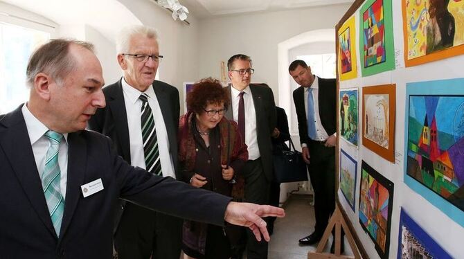 Historiker Reinhold Halder (links) führt Ministerpräsident Winfried Kretschmann und seine Frau Gerlinde durch die Ausstellung vo