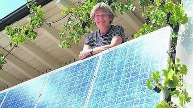 Von der Sonne verwöhnt: Edith Willmann und ihre Balkon-Solaranlage, über der die Weintrauben prächtig gedeihen. 
FOTO: TRINKHAUS