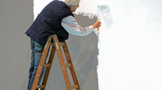 Ein älterer Herr streicht eine Wand auf der Leipziger Messe. Foto: Jan Woitas/Illustration