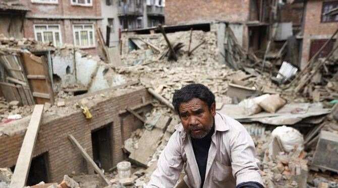 Nach dem Erdbeben in Nepal: Ein Mann steigt über die Trümmer seines Hauses. Foto: Abir Abdullah/Archiv