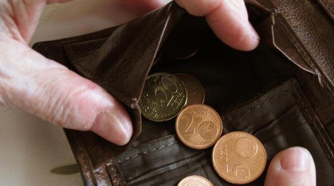 Eine Frau hält eine nahezu leere Geldbörse in den Händen. Foto: Jens Kalaene/Illustration