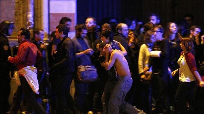 Vor der Konzerthalle Bataclan werden Verwundete in Sicherheit gebracht. Foto: Yoan Valat