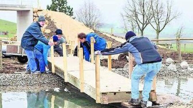 Eine von den TSG-Radsportlern selbst gezimmerte Holzbrücke führt über den Teich im neu gestalteten Mountainbike-Park.  FOTO: REI