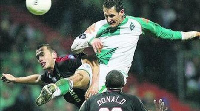 Durchgesetzt: Miroslav Klose (helles Trikot) und Werder Bremen überspringen die Hürde Ajax Amsterdam. 
FOTO: DPA